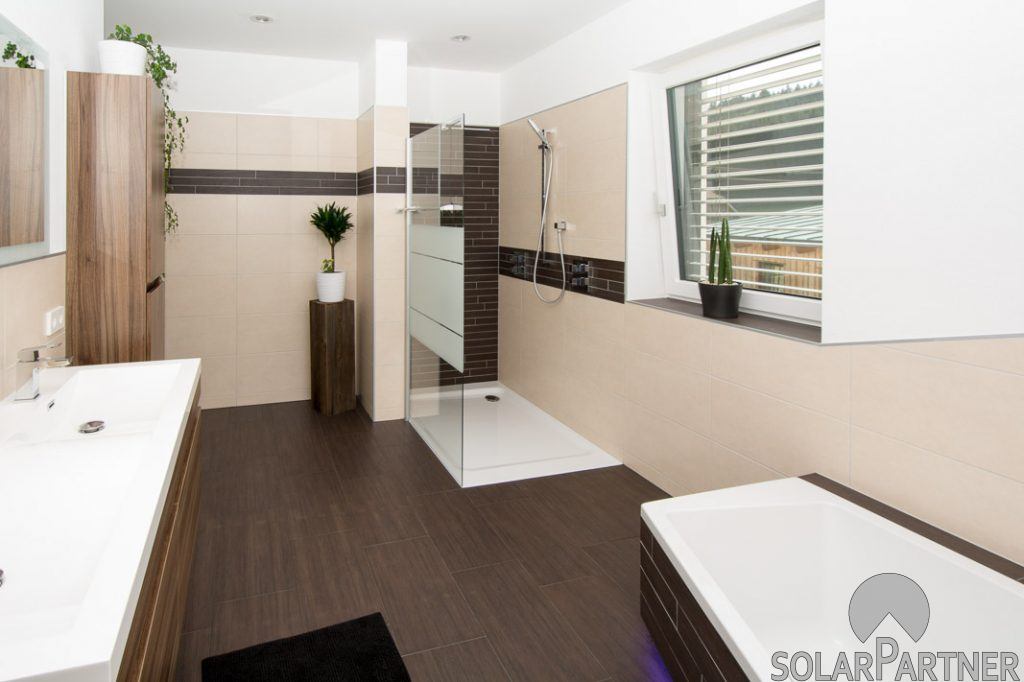 Walk-in-Dusche mit Glaswand samt Handtuchhalter.